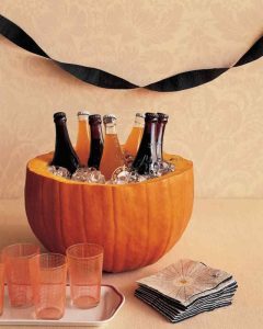 bottles in a pumpkin being used as a coolerg